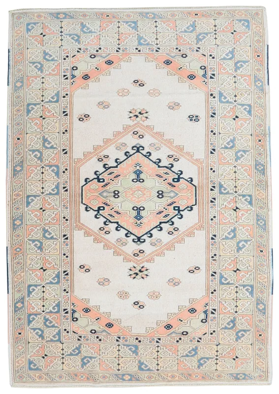 Full overhead view of a vintage ivory, rose, and blue tribal medallion rug