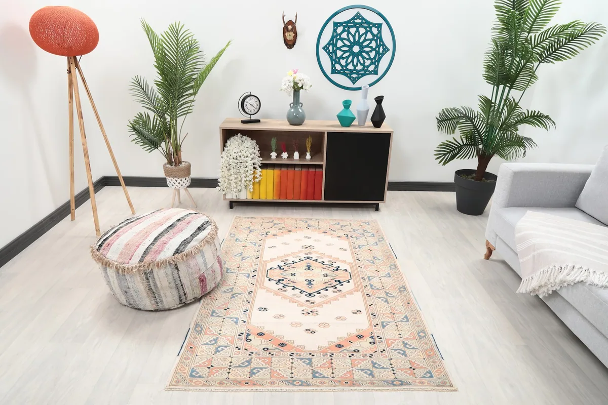 Vintage ivory and rose rug displayed in a living room setting with modern furniture