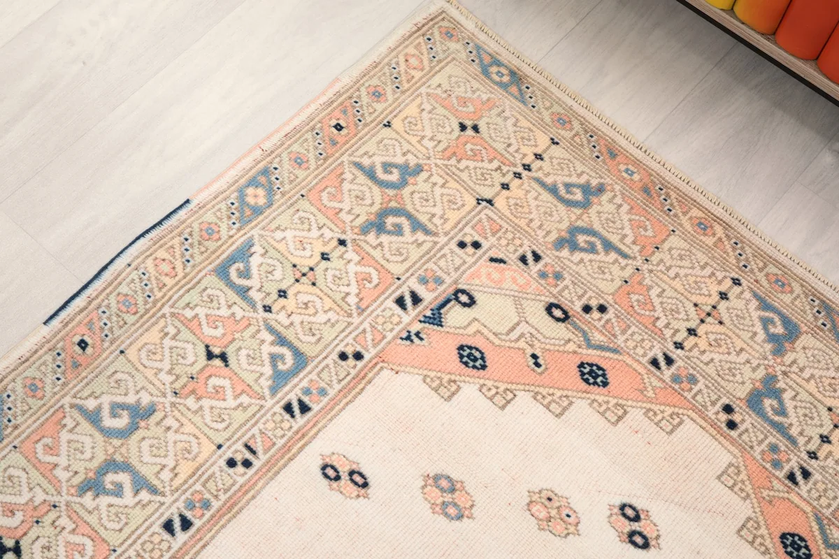Corner detail of the rug's border, showing the blending of rose and blue geometric motifs