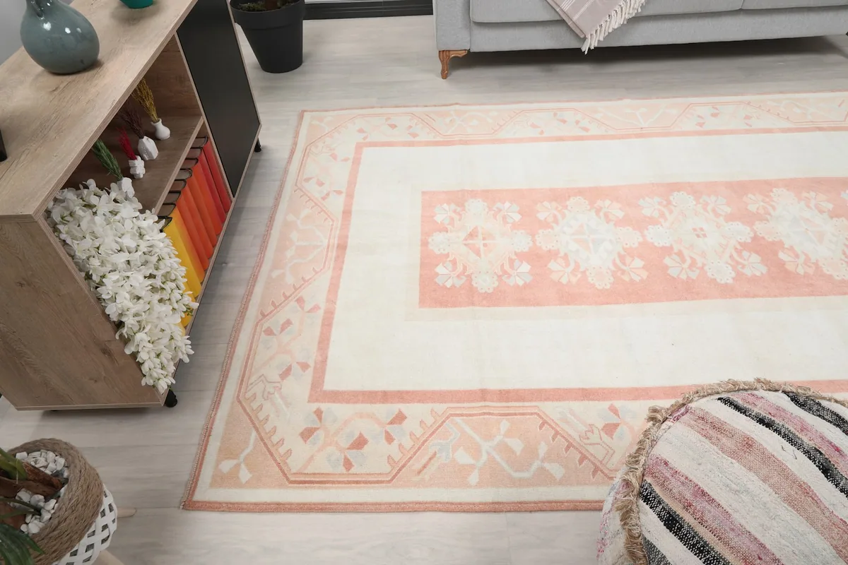 Lower corner angle of the ivory and rose rug in a room