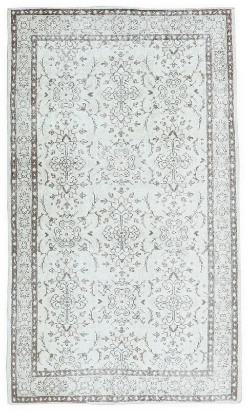 Full overhead view of the ivory and brown vintage Anatolian area rug on a white background.