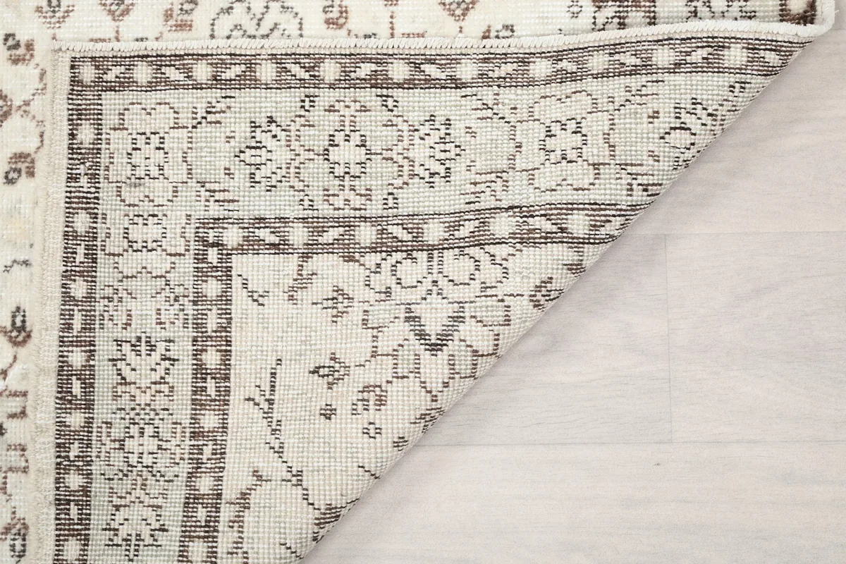 Another view of a folded rug corner, showing the craftsmanship and the thickness of the vintage wool pile.