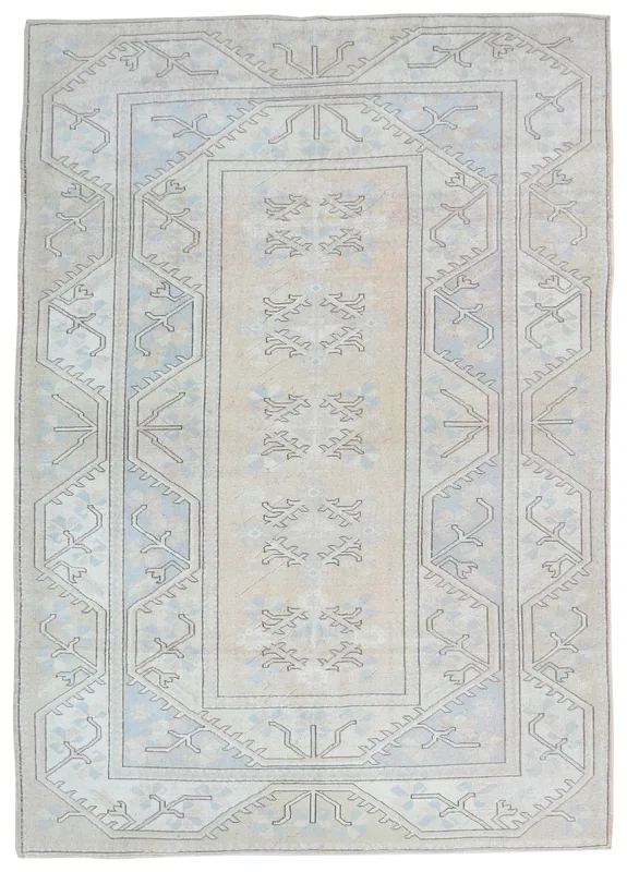 Full top view of a beige and blue geometric vintage Anatolian rug on a white background