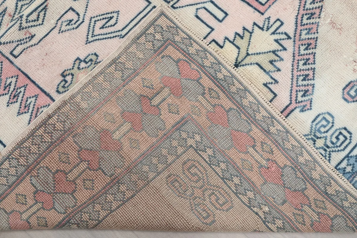 View of the back of the rug, showing the hand-knotted cotton foundation and wool knots