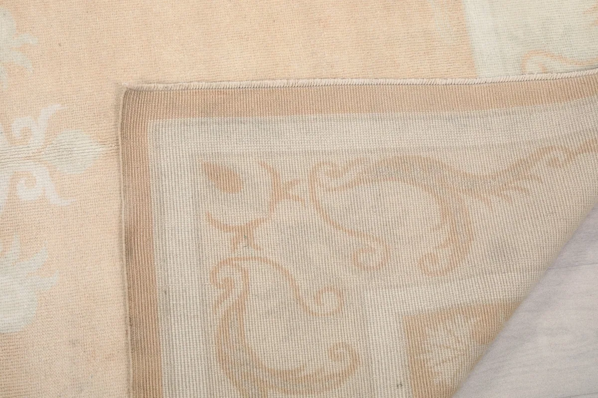 Close-up of the folded rug corner, showing the tightly woven cotton foundation and wool pile