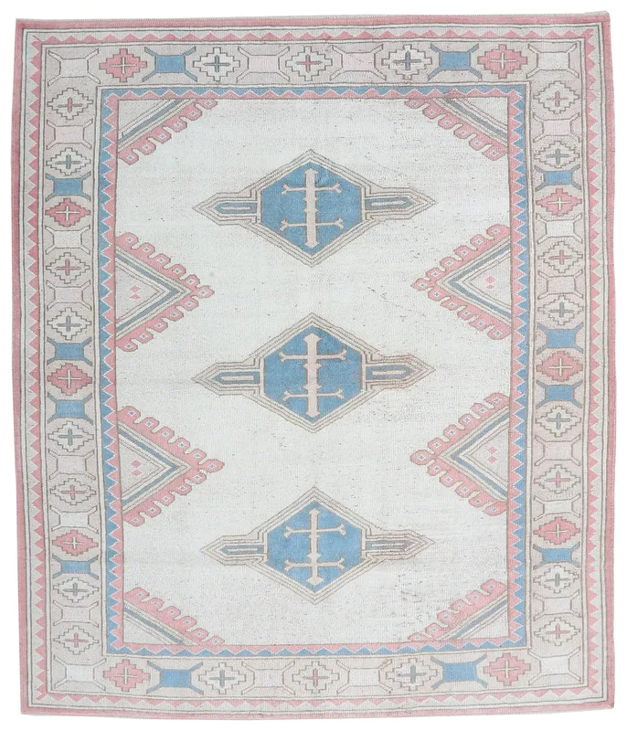 Full overhead view of the ivory, blue, and rose vintage Anatolian rug on a white background