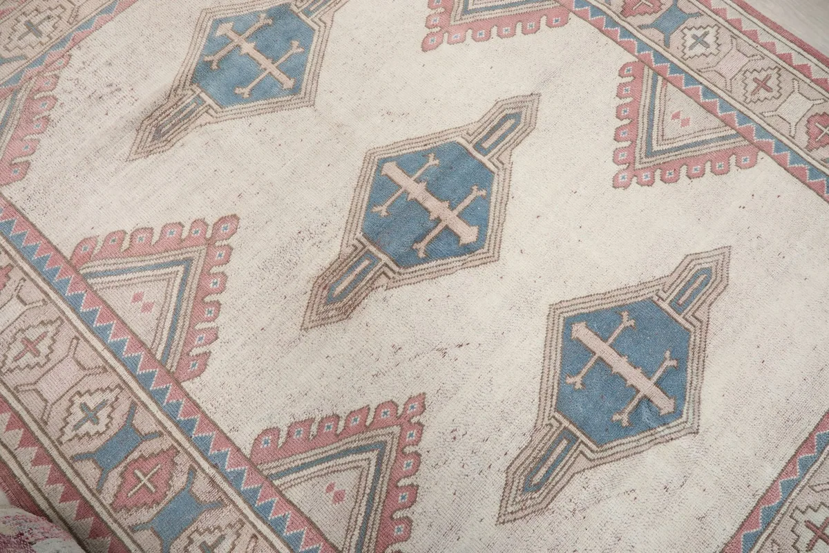 Overhead angle showing the three central blue geometric motifs on the ivory field