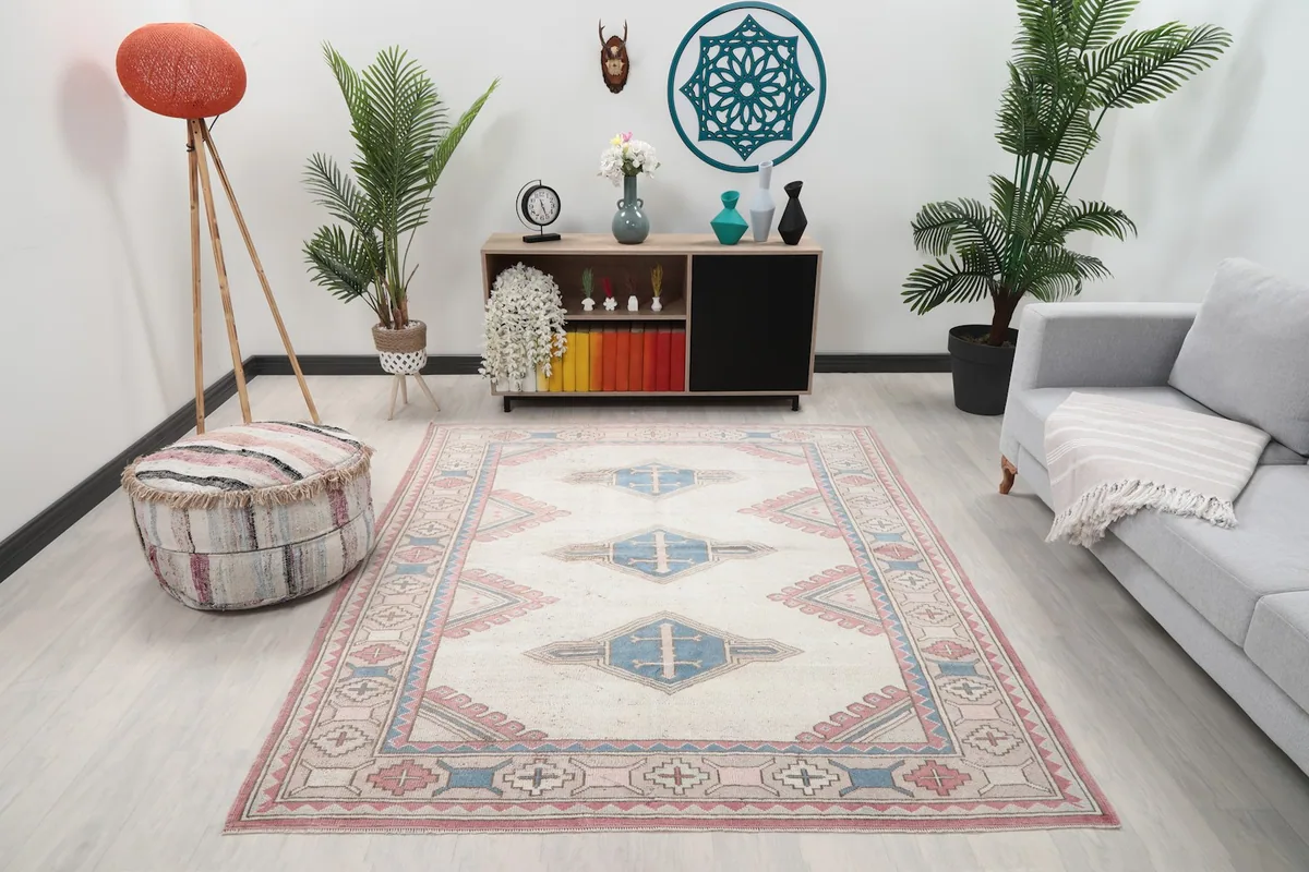 Vintage Anatolian rug with ivory, blue, and rose tones in a modern living room setting