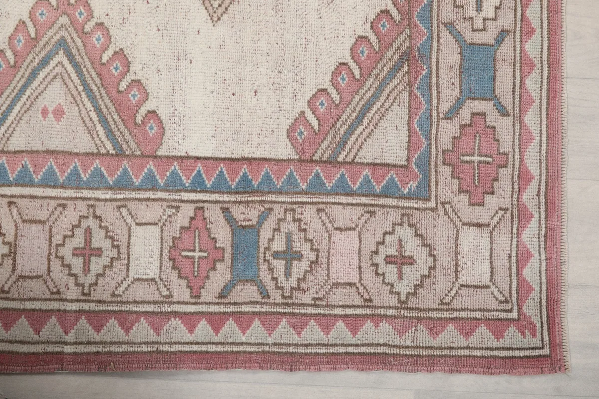 Detailed view of the corner border design with rose, blue, and ivory motifs