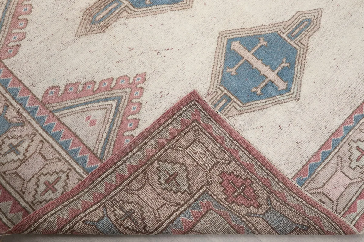 Corner of the rug folded back, showing the back of the hand-knotted wool pile