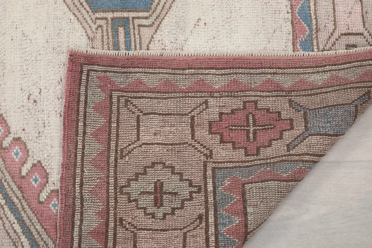 Folded corner of the rug, revealing the intricate knotting and foundation