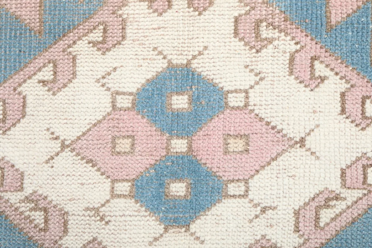 Macro shot of the hand-knotted wool pile, showing the texture and colors within a design element