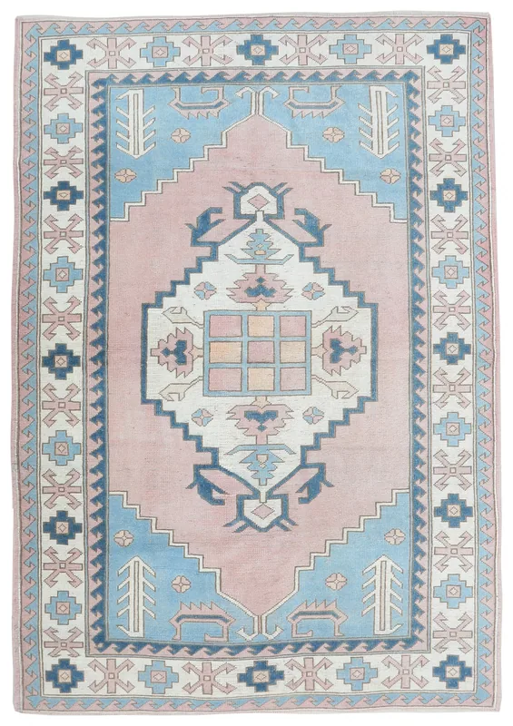 Full top view of the vintage pink and blue geometric Anatolian rug on a white background