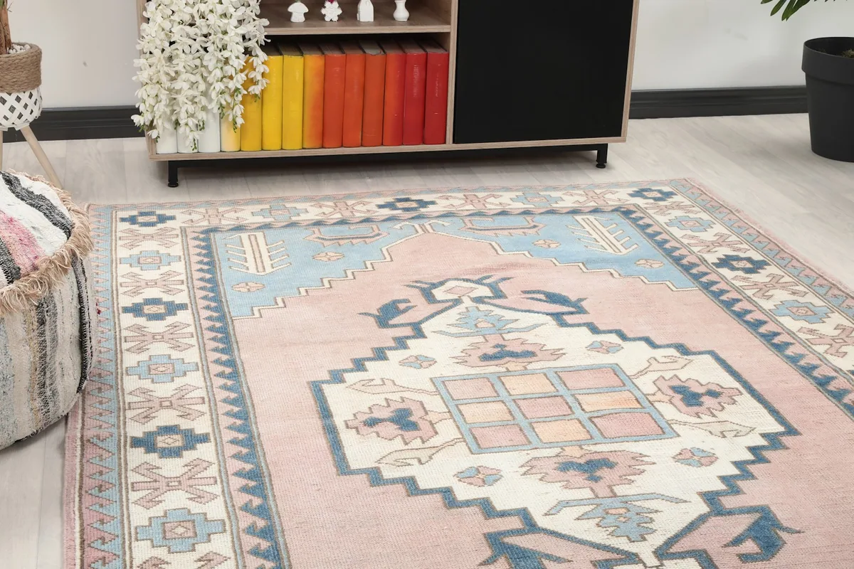 Close-up angle showing the central medallion and part of the border of the pink and blue rug