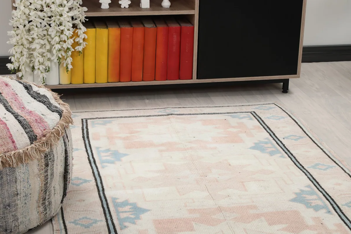 Close-up view of the rug's surface, showing colors and motifs in a room setting.