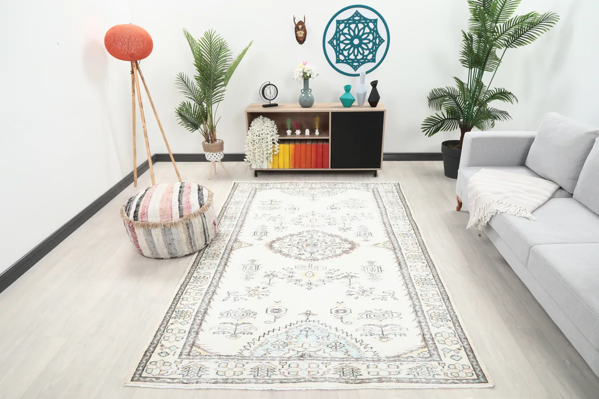 Ivory Tribal Medallion Rug in a room setting with a light gray sofa and wooden cabinet.