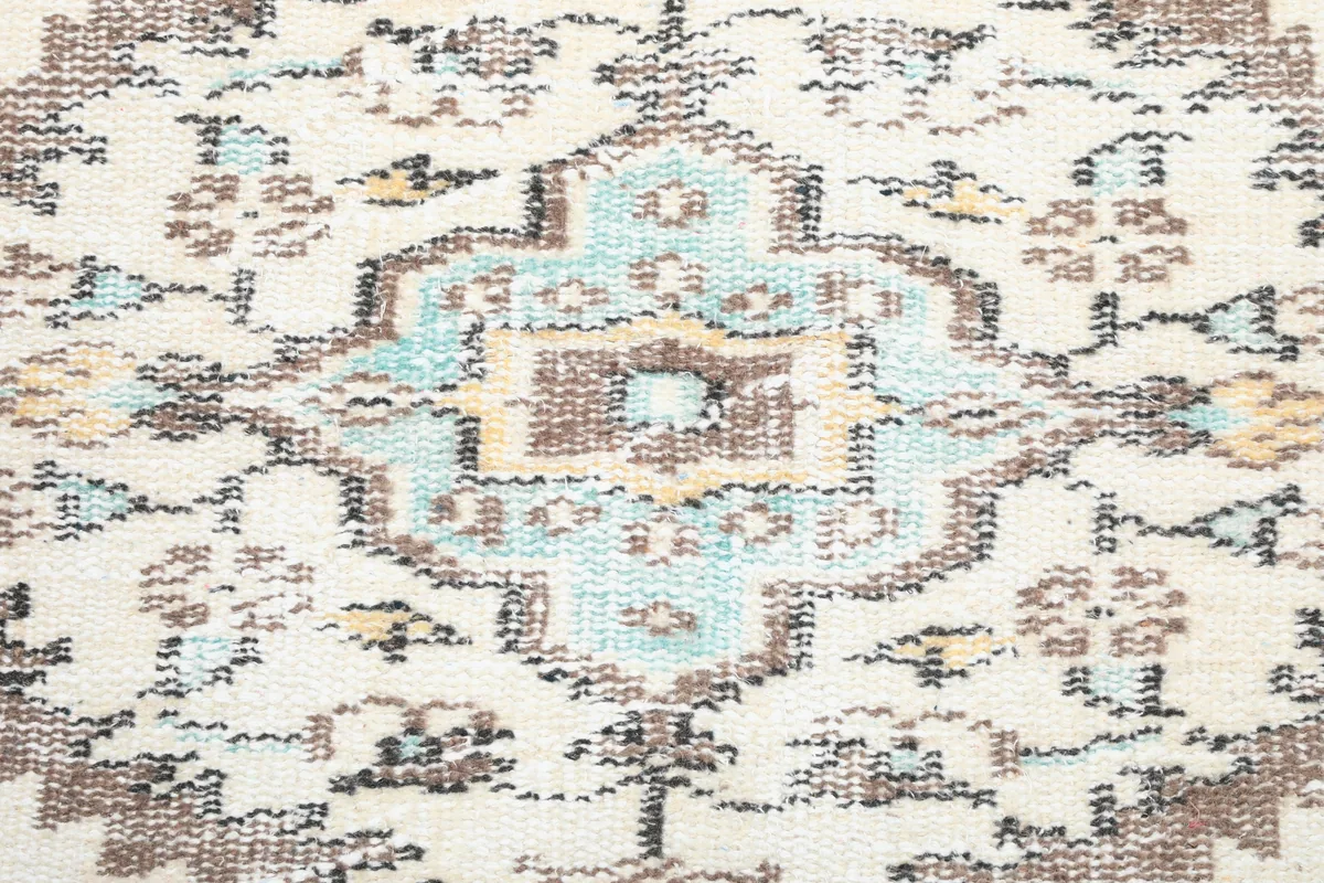 Detailed view of the central medallion on the Ivory Tribal Medallion Rug, showing blue, tan, and gray colors.