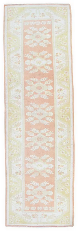 Full top view of the vintage pink and yellow Anatolian runner rug on a white background