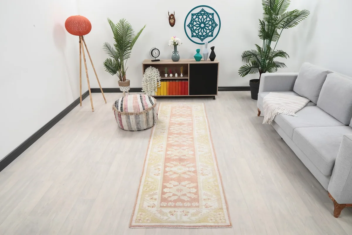 Vintage pink and yellow runner rug in a modern living room setting with light wood floors