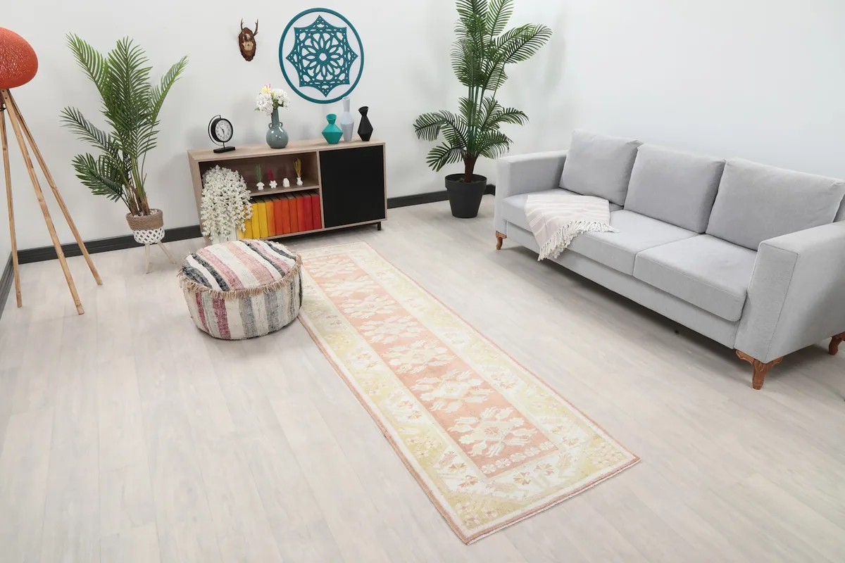 Angle view of the runner rug in a room, showing its length next to a sofa and cabinet