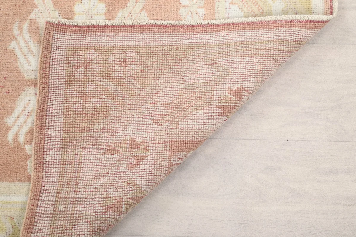 Angled shot of the back of the rug, showing the wool pile knots on the cotton foundation
