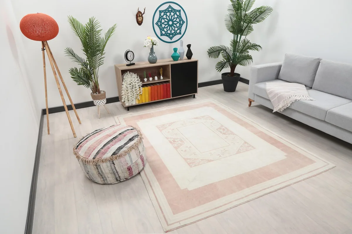 Overhead view of the rug in a living room, showing its placement relative to a sofa and ottoman