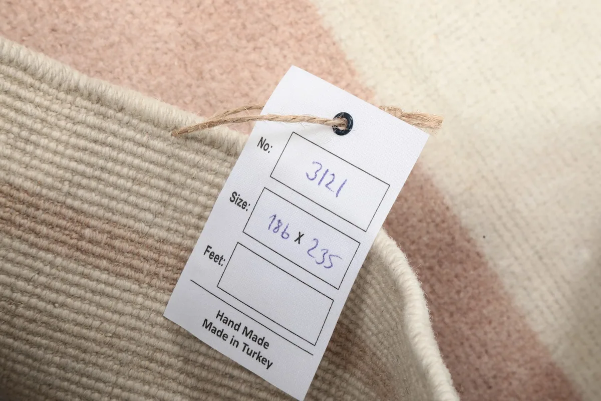 Tag showing the rug's dimensions in centimeters and feet, and origin as hand made in Turkey