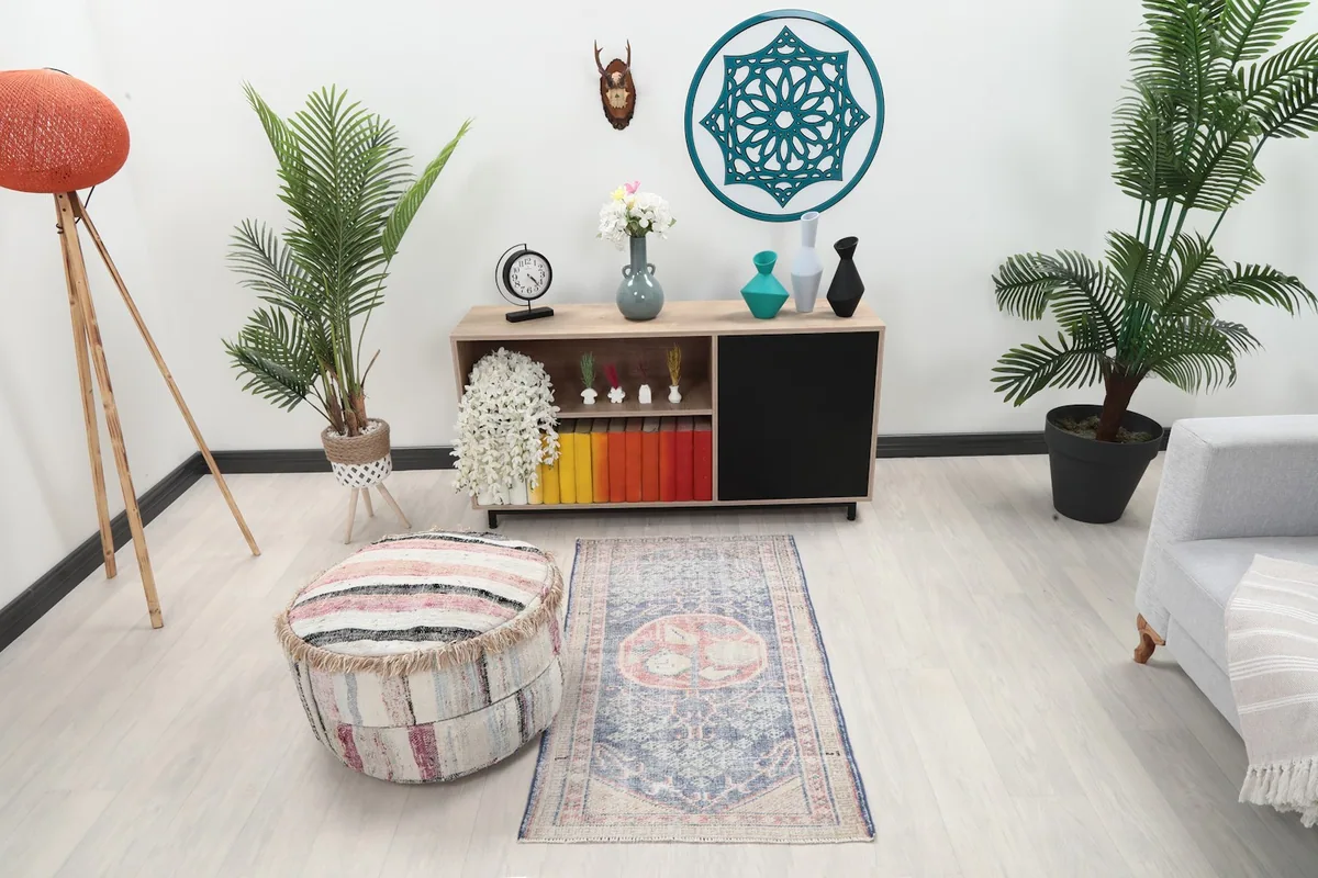 Vintage blue and rose rug placed in a modern living space with light-colored furniture.