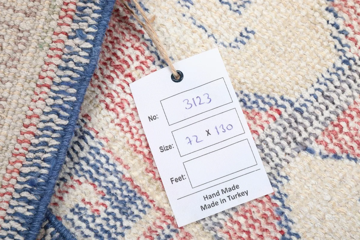 Close-up of the product tag attached to the rug, displaying size and origin information.