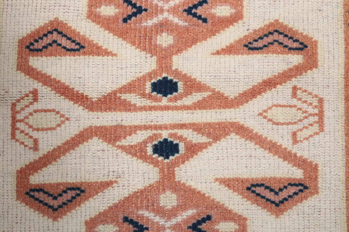 Close-up of a central geometric motif on the Ivory Geometric Anatolian Runner, showing knot detail and color variation.