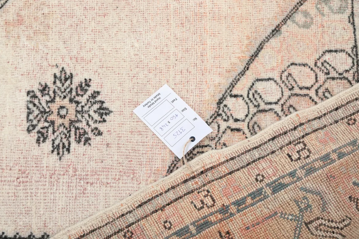 Close-up of the rug's label and a folded corner, showing the cotton foundation