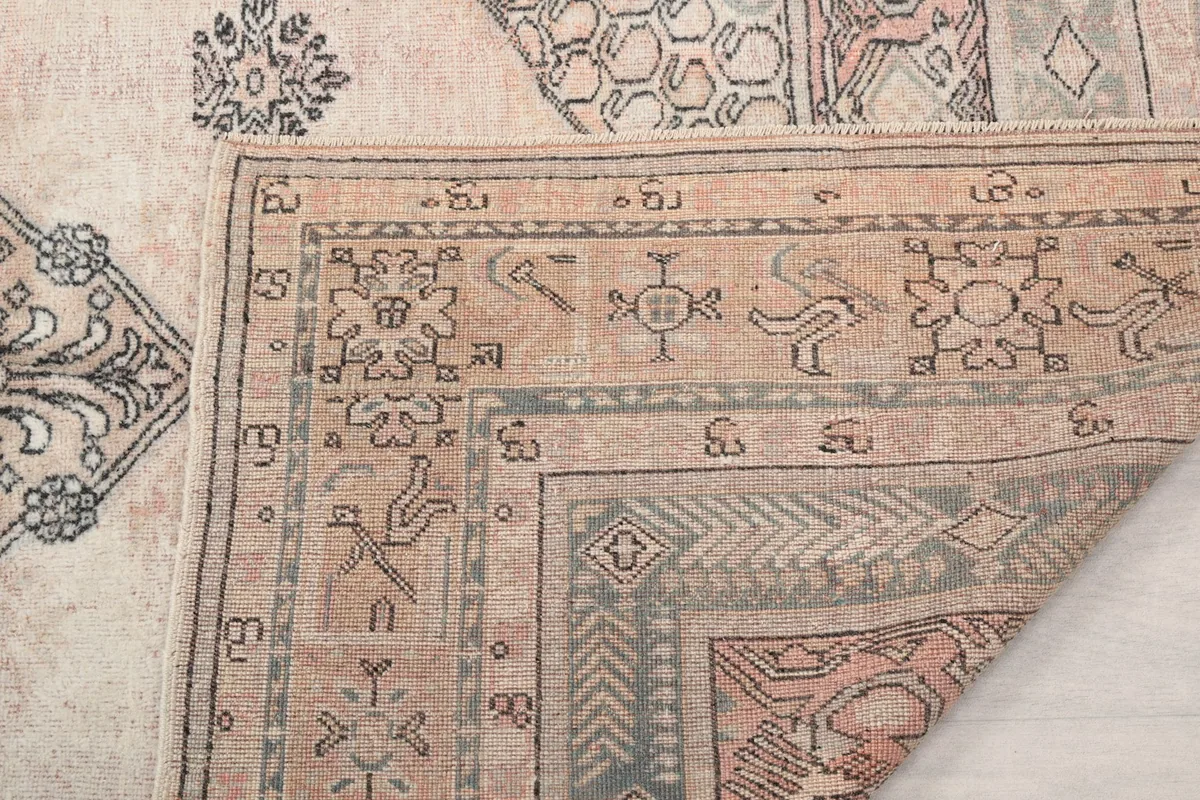 Detail of the rug's edge and fringe, showing the hand-knotted wool pile