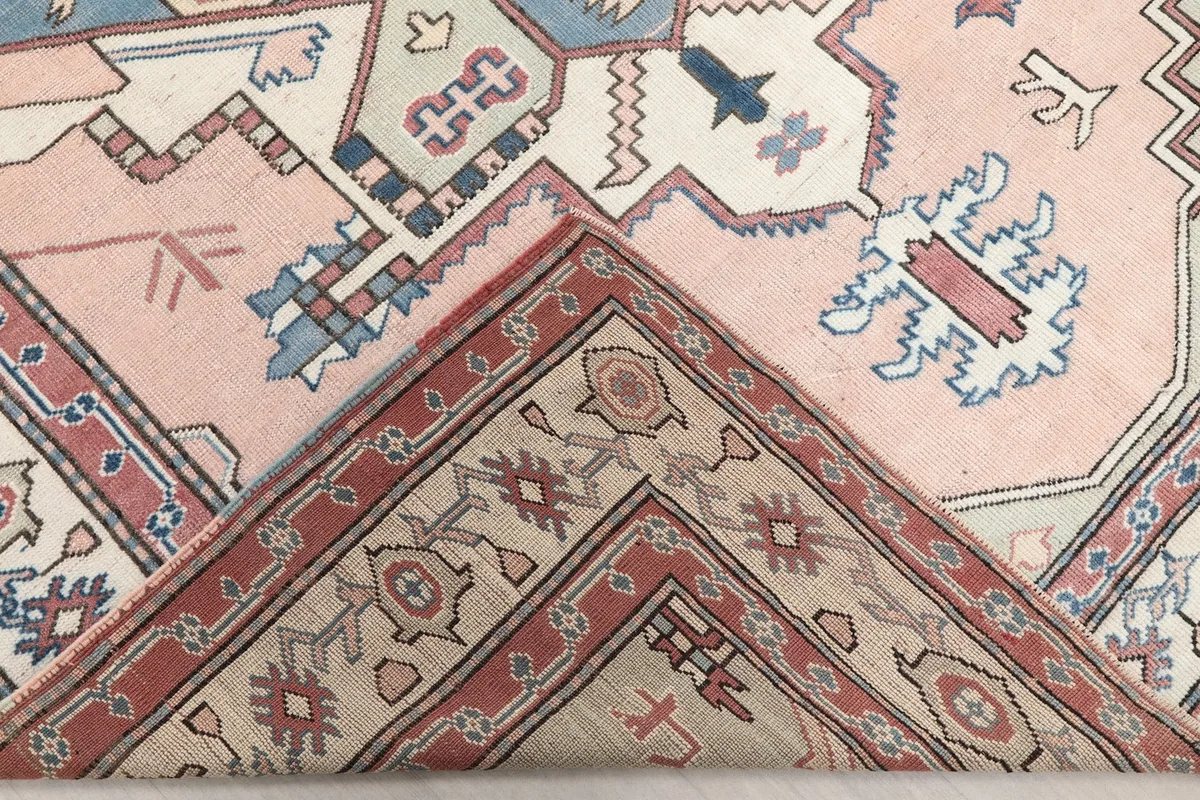 Corner of the rug folded back to reveal the cotton foundation and reverse side of the hand-knotted construction.