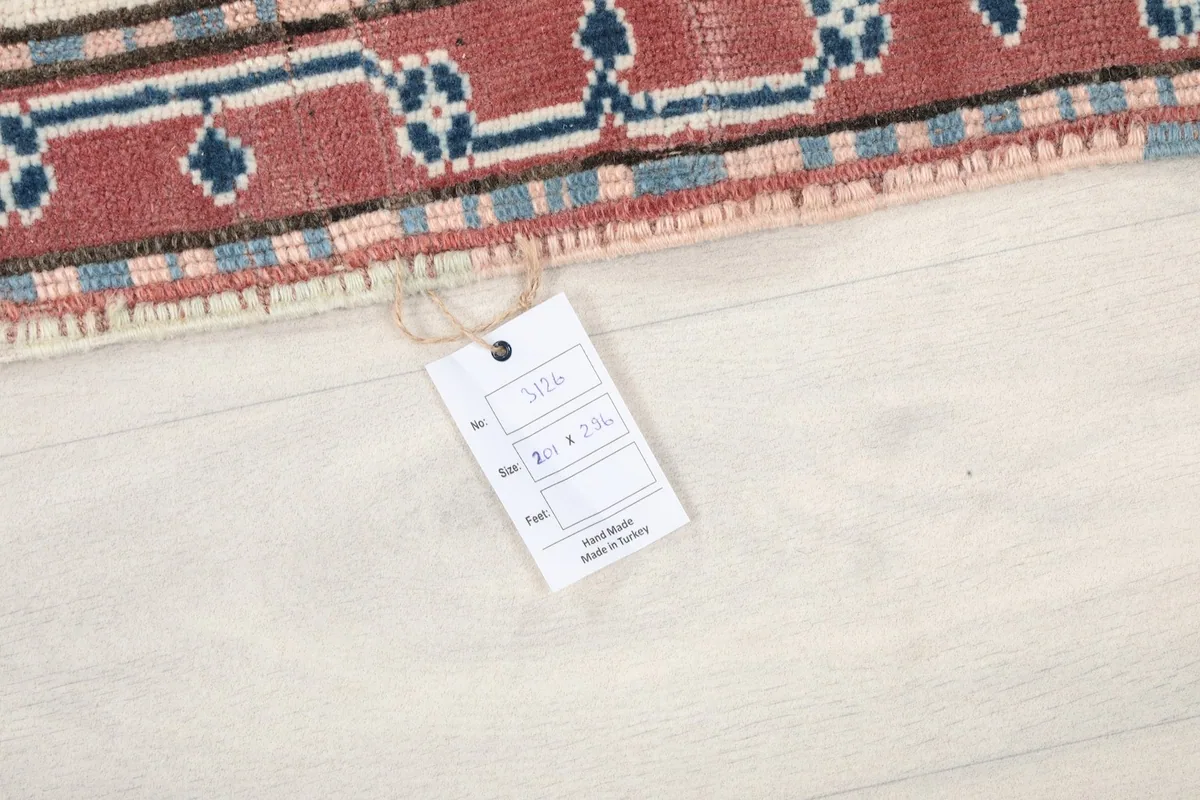 Tag displaying the rug's size (6'7" x 9'9") and origin (Hand Made in Turkey) on the floor.