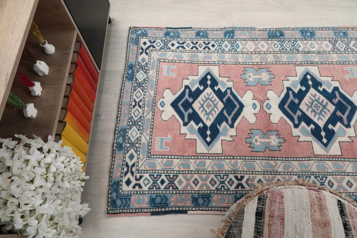 Angled shot of the rug from above, showing its placement relative to a decorative pouf and cabinet.
