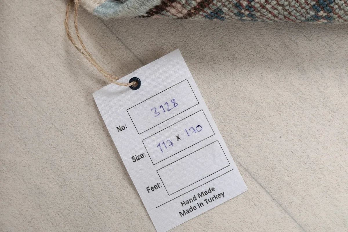 Tag showing the rug's identification number and size in centimeters, confirming handmade origin.