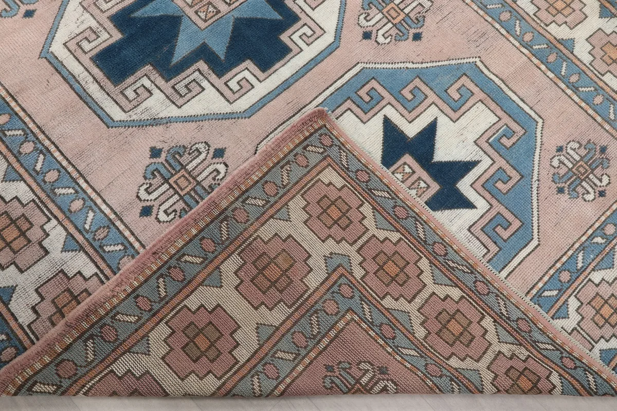 Folded corner of the rug revealing the thickness of the hand-knotted wool pile and cotton foundation