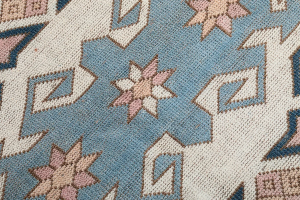 Close-up detail of the hand-knotted wool pile and intricate geometric patterns within the medallion