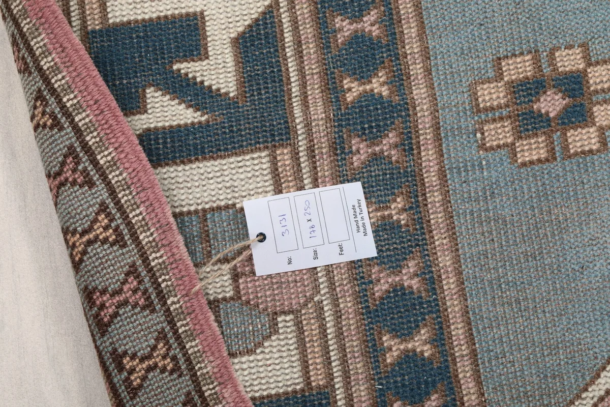 Close-up of the rug's back with a product tag, showing the detailed weave and construction