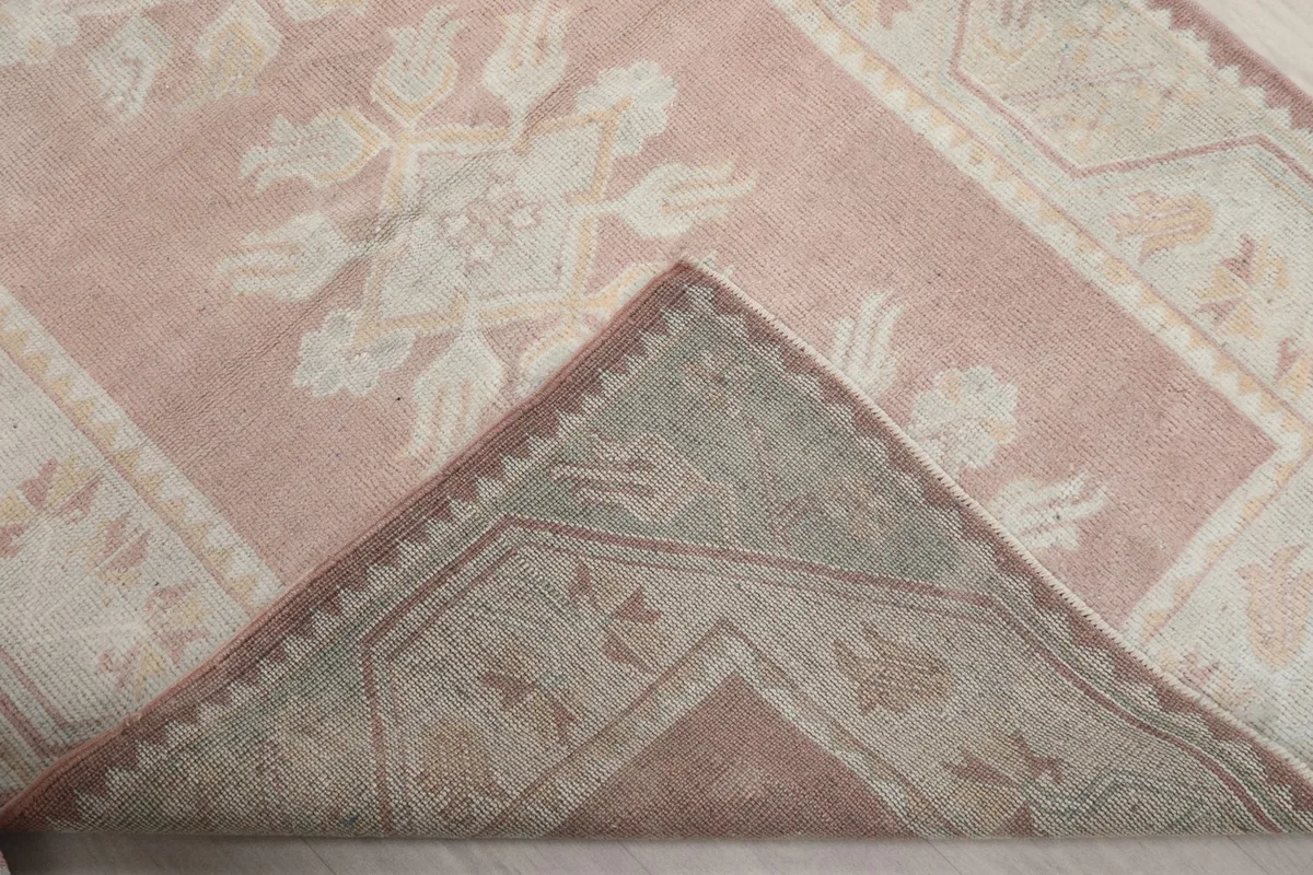 Folded corner of the rug revealing the cotton foundation and reverse side