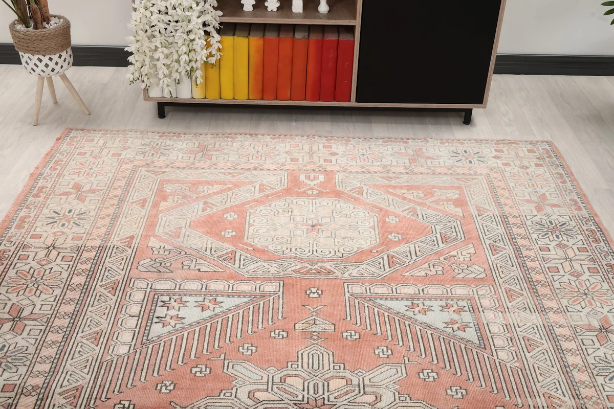 View of the rug from one end in a room setting, showing the full design and muted colors