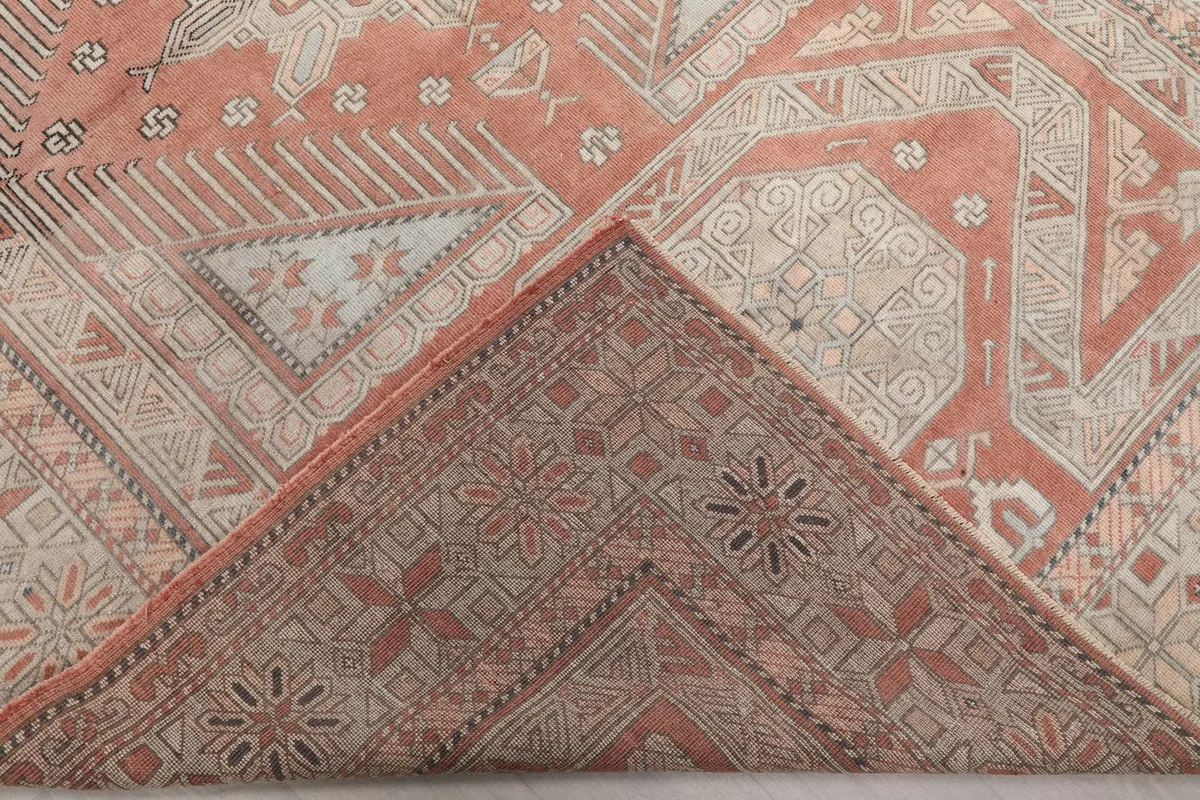 Folded corner of the rug revealing the cotton foundation and the reverse side of the hand-knotted weave