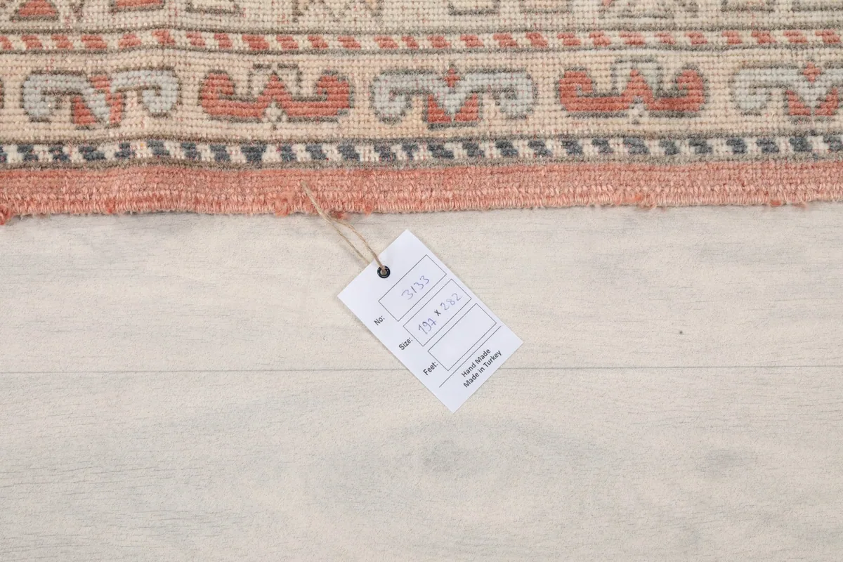 Product tag on the rug, displaying size and material information, on a light wooden floor