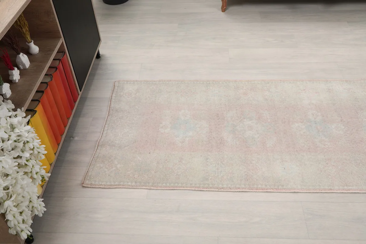 View along the length of the runner rug, showing its faded color variations and patterns