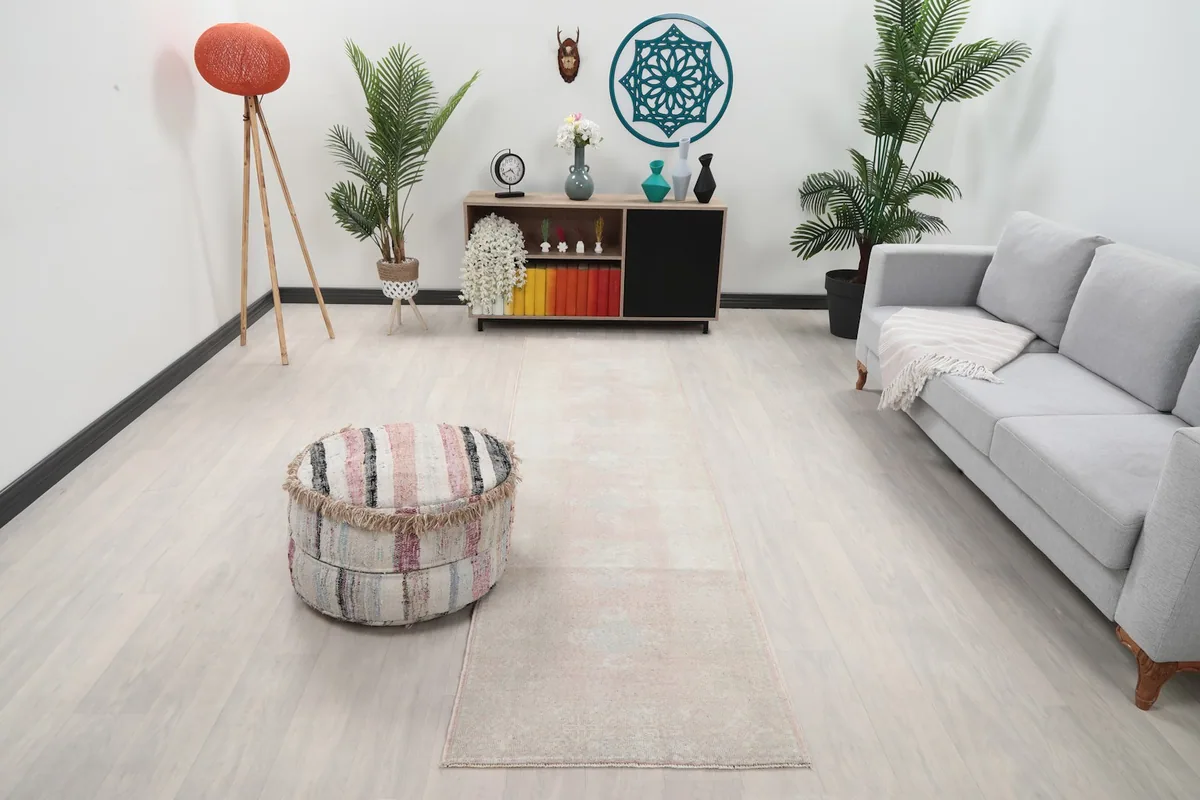Runner rug placed in a modern living room setting with a sofa and ottoman