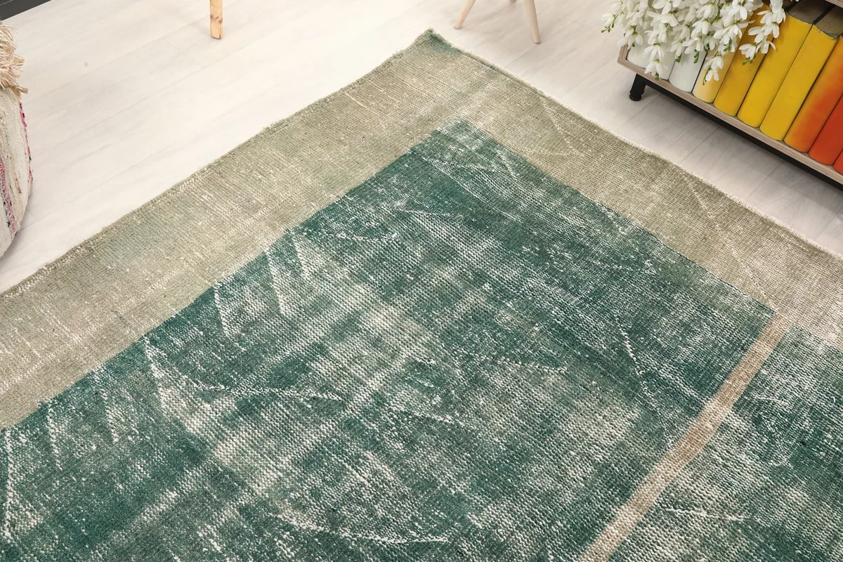 Angled detail shot showcasing the texture and color variation in the rug's green and gray areas