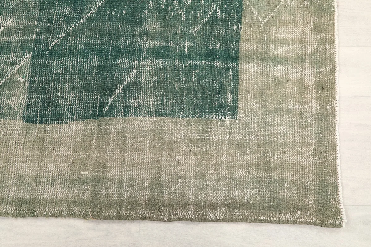 Detail of the gray-beige border and corner of the vintage hand-knotted rug