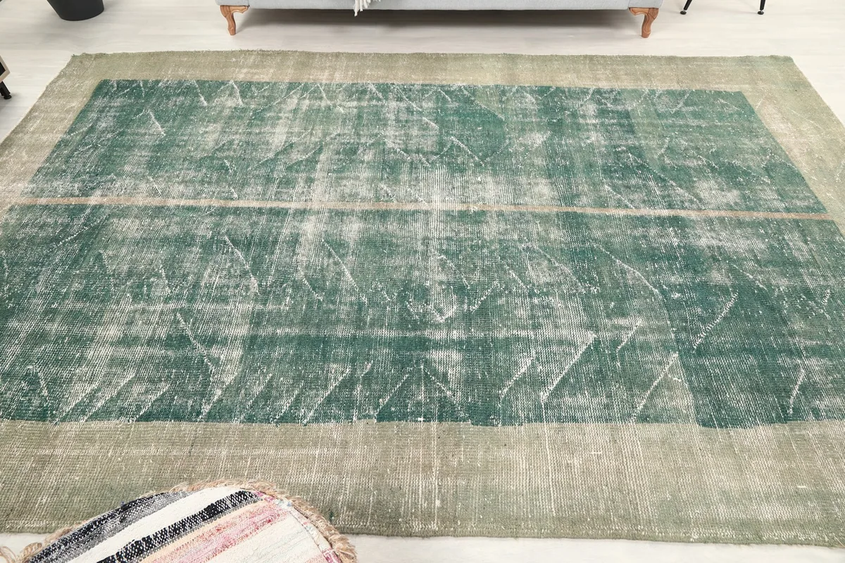 Full overhead view of the green and gray vintage rug, showing its rectangular shape