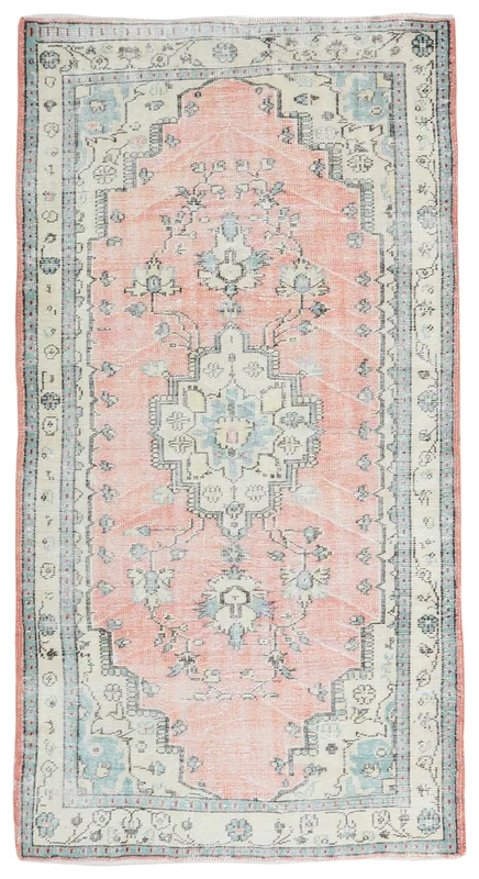 Full top view of the rose, ivory, and blue vintage Anatolian rug on a white background.
