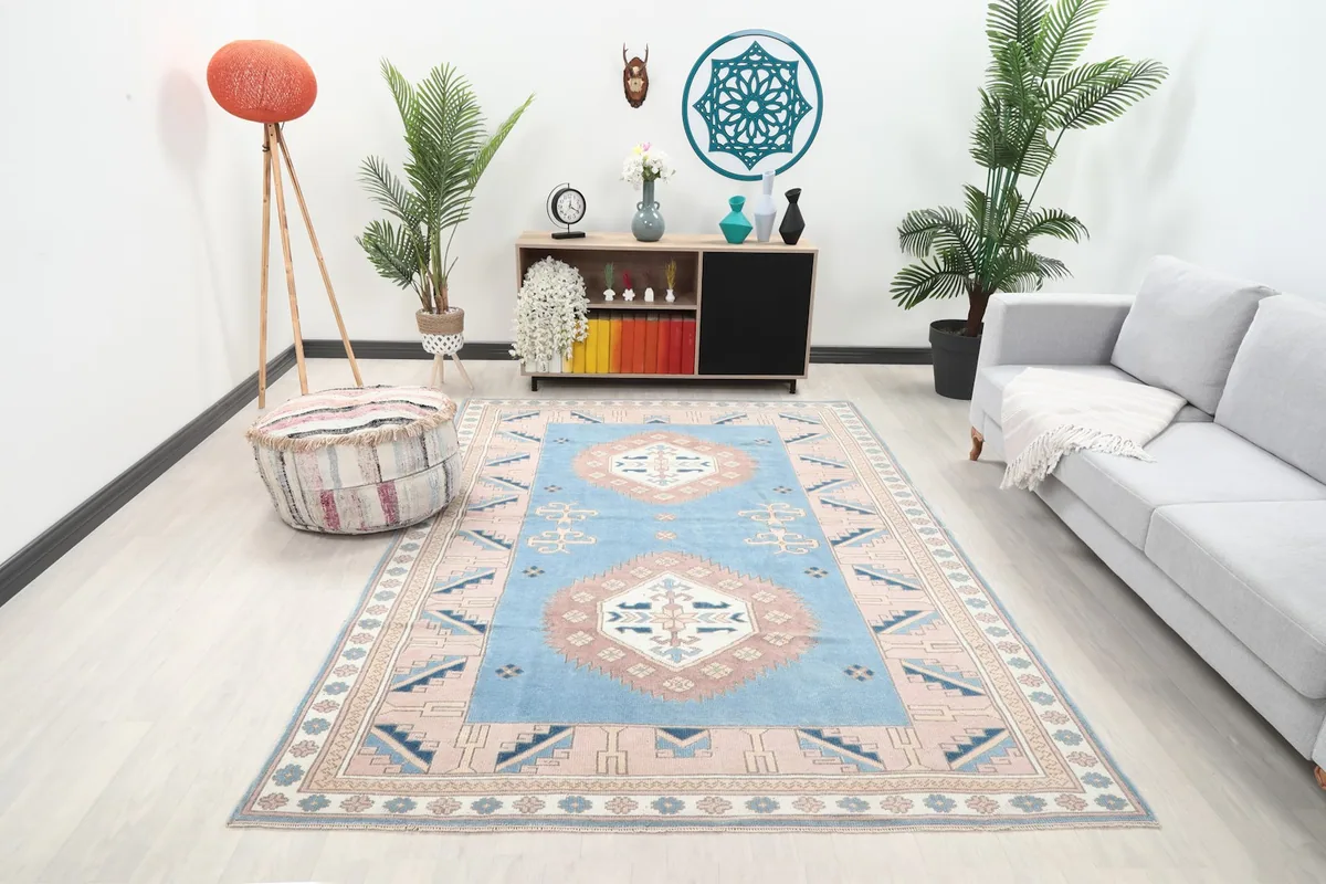 Vintage Anatolian rug with blue and rose tones in a modern living room setting